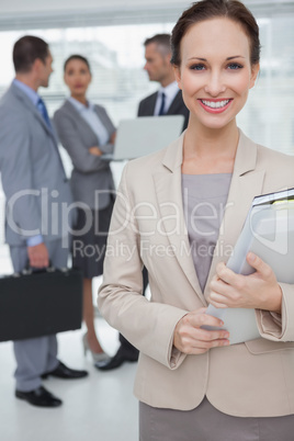 Cheerful businesswoman holding files posing