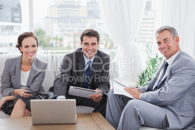Business people smiling at camera while having a meeting