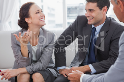Businesswoman smiling while her partners looking at her