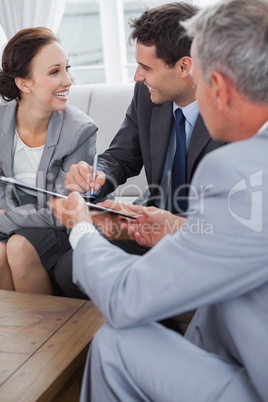 Businessman signing contract while looking at his partner