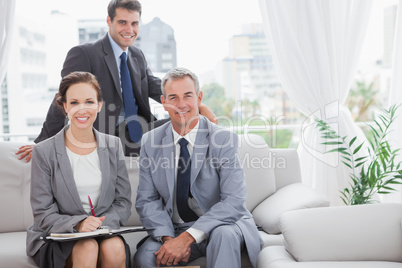Smiling partners posing while having a meeting