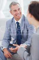 Smiling businessman talking to his workmate