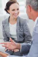 Smiling businesswoman listening to her workmate talking