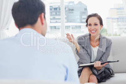 Cheerful businesswoman talking to her colleague