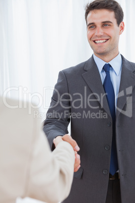 Cheerful businessman shaking hands with his new workmate