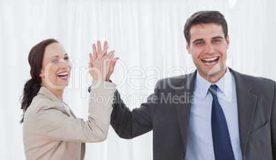 Cheerful workmates doing high five