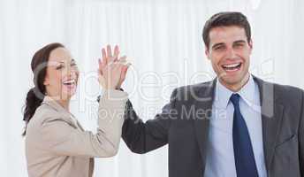 Cheerful workmates doing high five