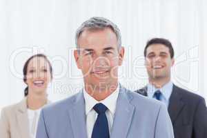Experienced businessman posing with his work team