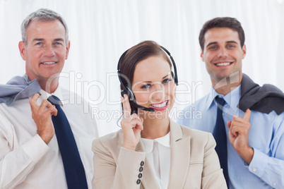 Smiling call center agent posing with her work team