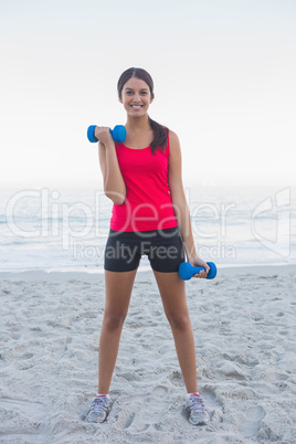 Sporty woman exercising with dumbbells