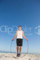 Cheerful sporty man jumping rope