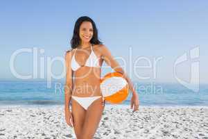 Cheerful sexy brunette in white bikini with beach ball