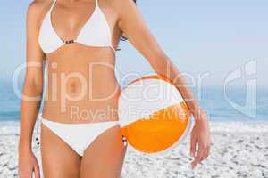 Sexy female body in white bikini with beach ball
