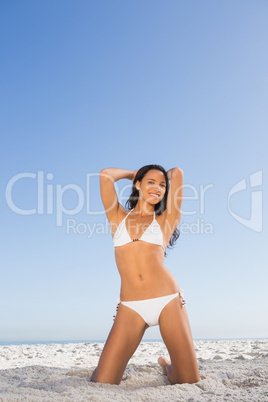 Smiling attractive woman in white bikini posing