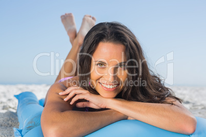 Smiling attractive brunette relaxing on her lilo