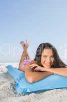 Cheerful attractive brunette relaxing on her lilo