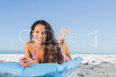 Happy attractive brunette relaxing on her lilo