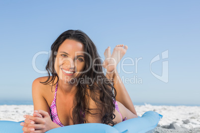 Happy attractive brunette lying on her lilo