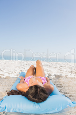 Attractive young brunette lying on her lilo