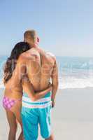 Sexy couple hugging while looking at the sea