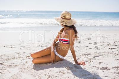 Young sexy woman wearing straw hat taking sun