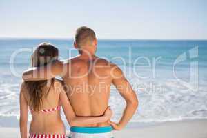 Loving couple embracing one another while looking at the sea