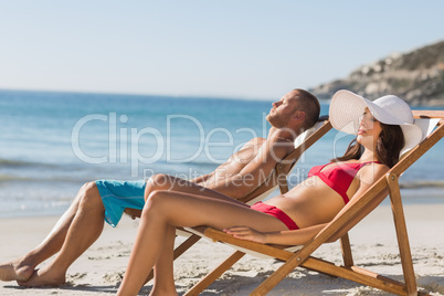 Young couple sleeping on their deck chairs