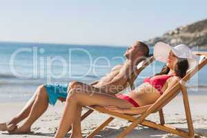 Young couple sleeping on their deck chairs