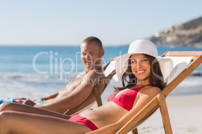 Young couple on their deck chairs smiling at camera