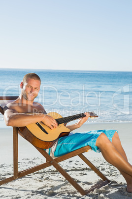 Cheerful handsome man strumming guitar