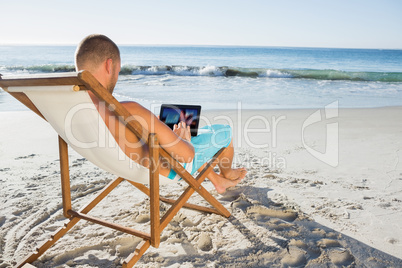 Handsome man scrolling on his tablet pc