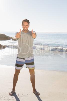 Smiling handsome man cshowing thumbs up to camera