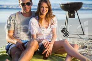 Smiling couple posing while having barbecue