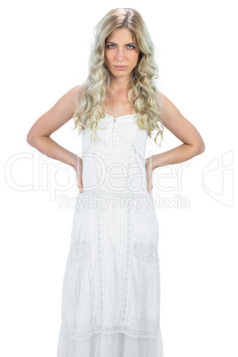 Serious gorgeous model in white dress posing