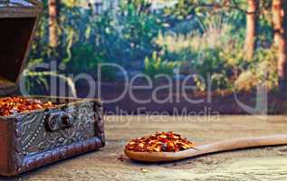 Dried red chilli flakes on rustic wooden table