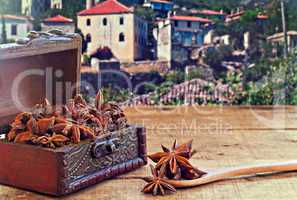 Star anise spice on rustic wooden table with old countryside vil