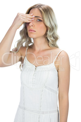 Attractive blond model having headache touching her forehead