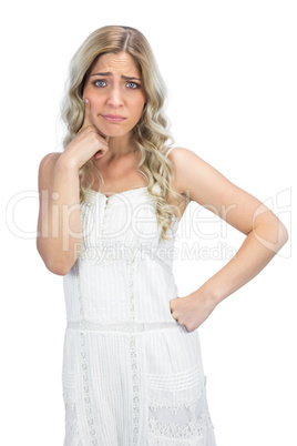 Doubtful curly haired blonde having interrogative posture