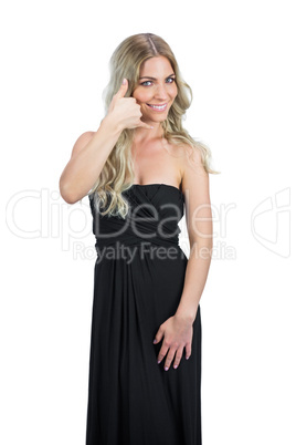 Attractive blonde with black cocktail dress making phone call ge