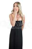 Shocked attractive blonde wearing black dress posing