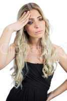 Gorgeous blonde wearing black dress having a headache