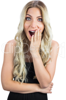 Surprised gorgeous blonde in black dress posing