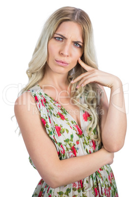 Frowning pretty blonde wearing flowered dress posing