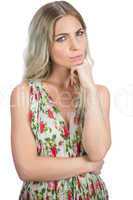 Thoughtful pretty blonde wearing flowered dress posing