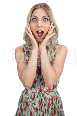 Surprised pretty blonde wearing flowered dress posing