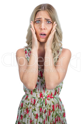 Unhappy blonde wearing flowered dress posing