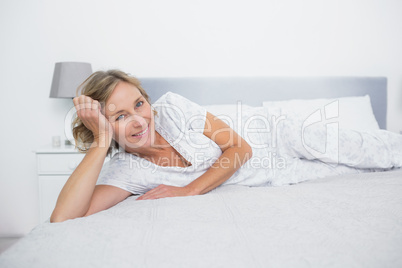 Relaxed blonde woman lying on bed