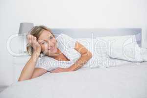 Relaxed blonde woman lying on bed