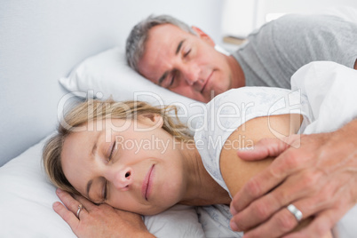 Calm couple sleeping and spooning in bed