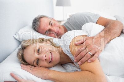 Couple lying in bed spooning